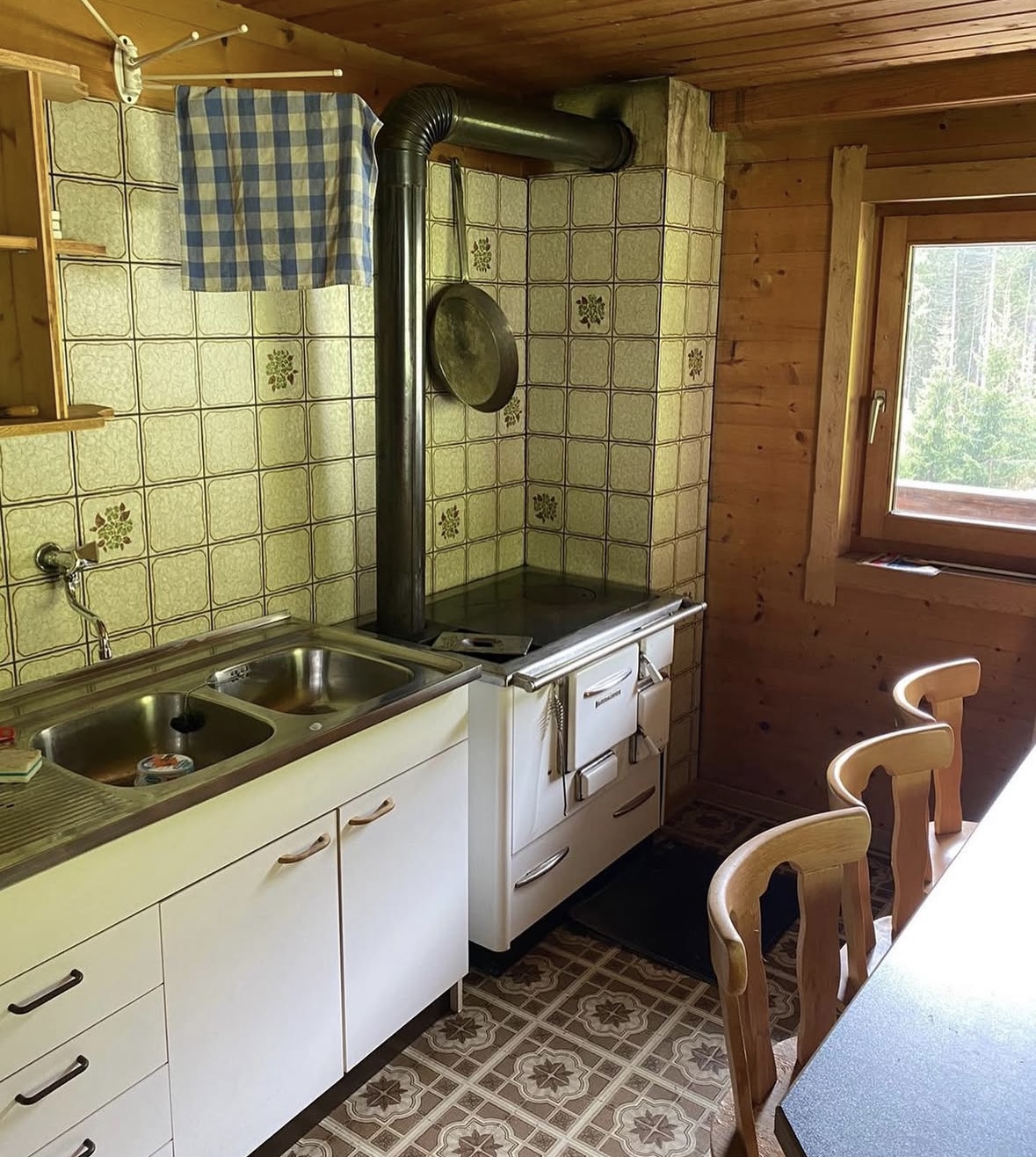 Traditionelle Küche mit Holzofen und Waldblick