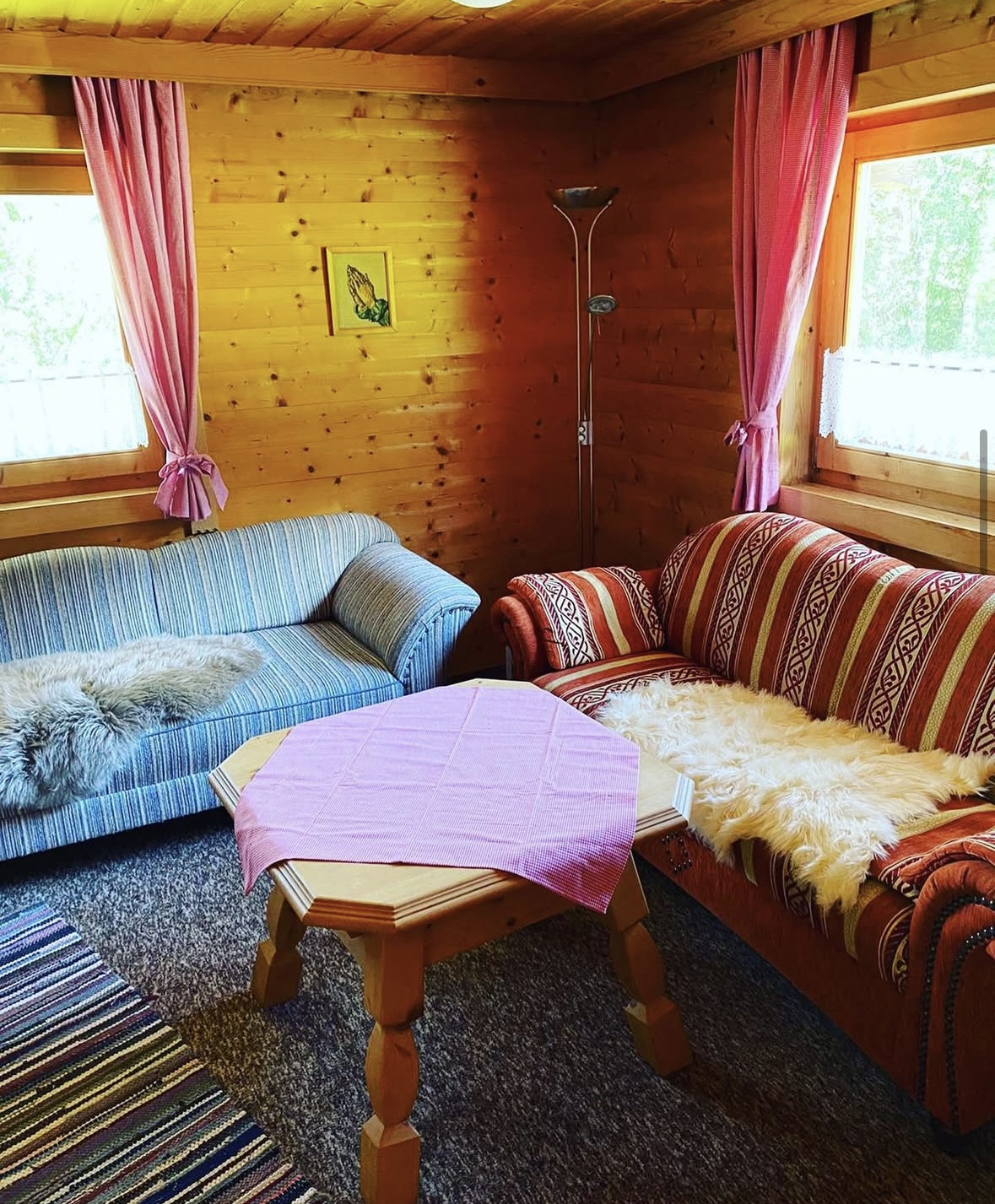 Gemütliches Wohnzimmer mit holzvertäfelten Wänden und Sitzgruppe